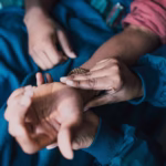 Close-up of hands checking a pulse on a patient